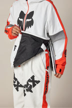A person wearing the 686 Women's Fox Racing Shell Anorak, showing its black patterned inner lining, is visible from the lower face and body.
