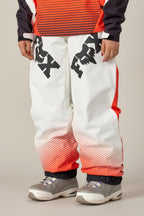 A person wearing the 686 Women's Fox Racing Shell Pant featuring black FOX logos, a red dotted pattern near the ankles, and a matching top with gray sneakers. Only the lower half of the body is visible.