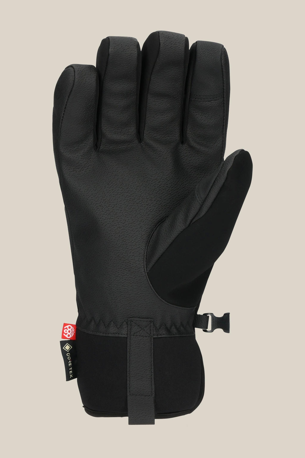 The 686 Men's GORE-TEX Linear™ Under Cuff Glove by 686 is a black insulated men’s glove with a textured palm, adjustable wrist strap, and a small fabric tag near the cuff, shown on a plain beige background.