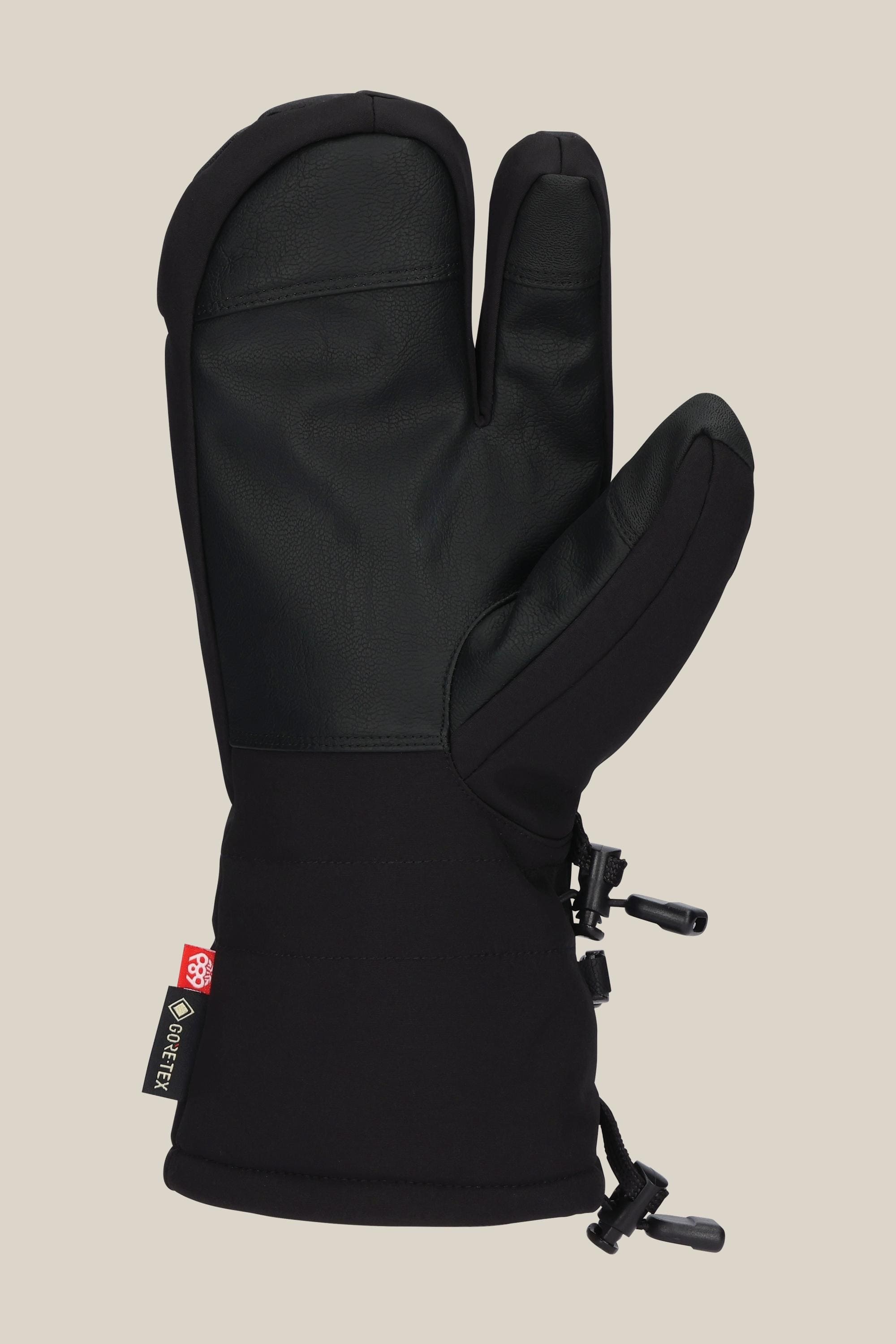 The 686 Men's GORE-TEX Linear Trigger Mitt by 686 is a black, insulated three-finger men's mitt with poly and PU materials, a textured palm, adjustable wrist cinch, and GORE-TEX tag, shown on a plain beige background.