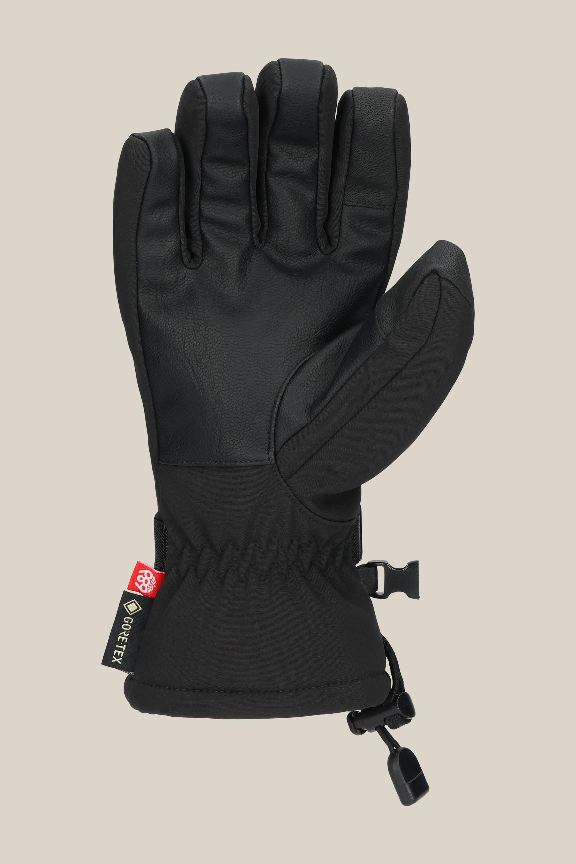The 686 Women's GORE-TEX Linear™ Glove, a black glove with reinforced fingers and thumb, an adjustable wrist strap, and a Gore-Tex tag, is shown against a light beige background.